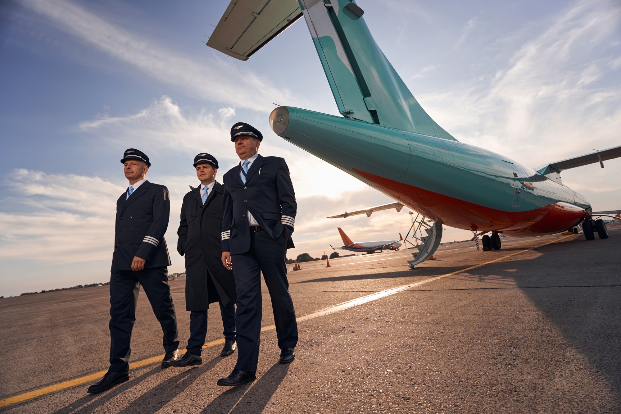 Three plane captains making a step forward from airplane